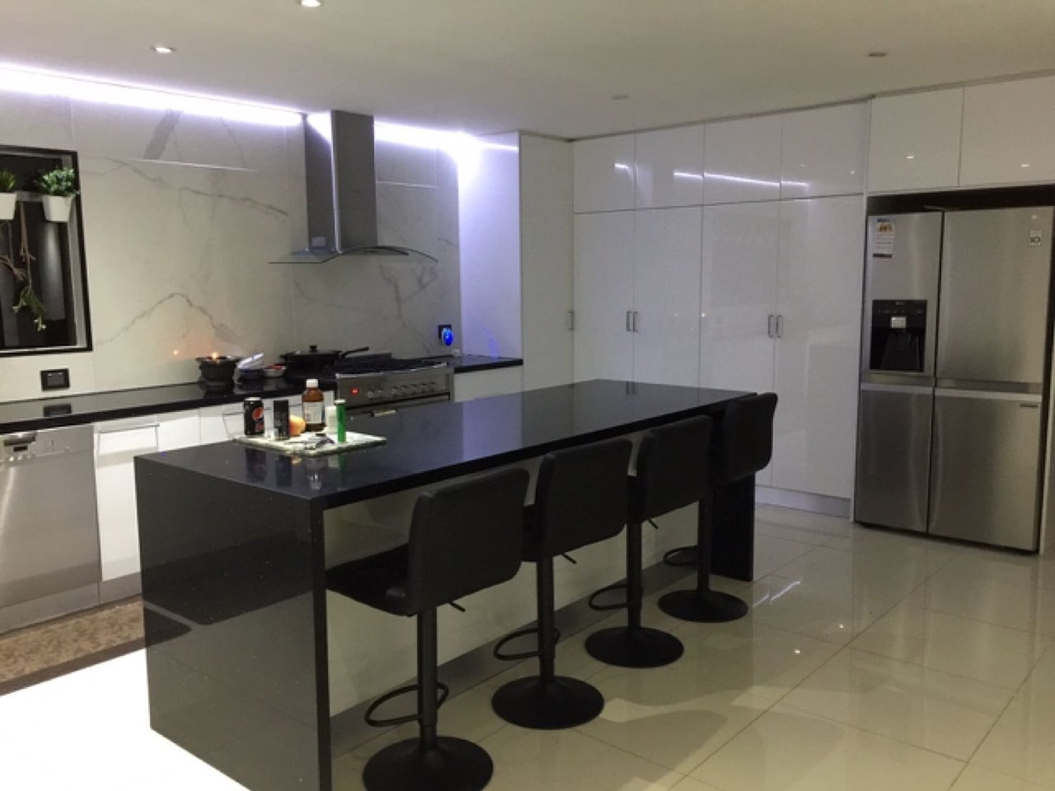 Gloss white kitchen with black stone island