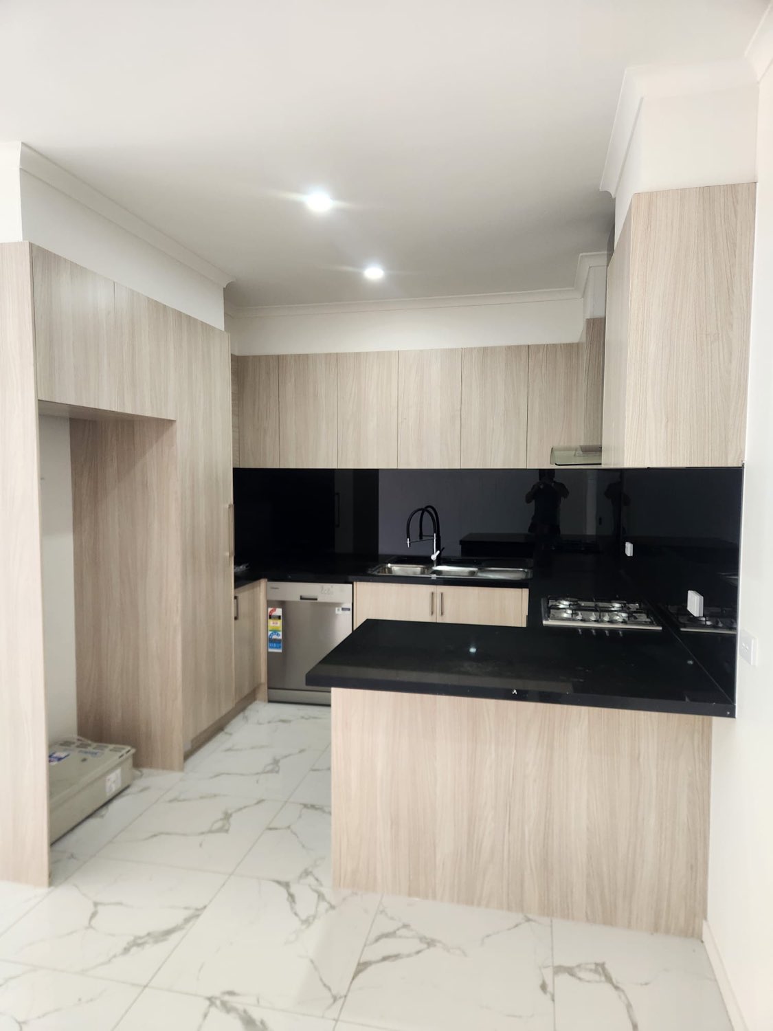 Oak and black kitchen with marble flooring