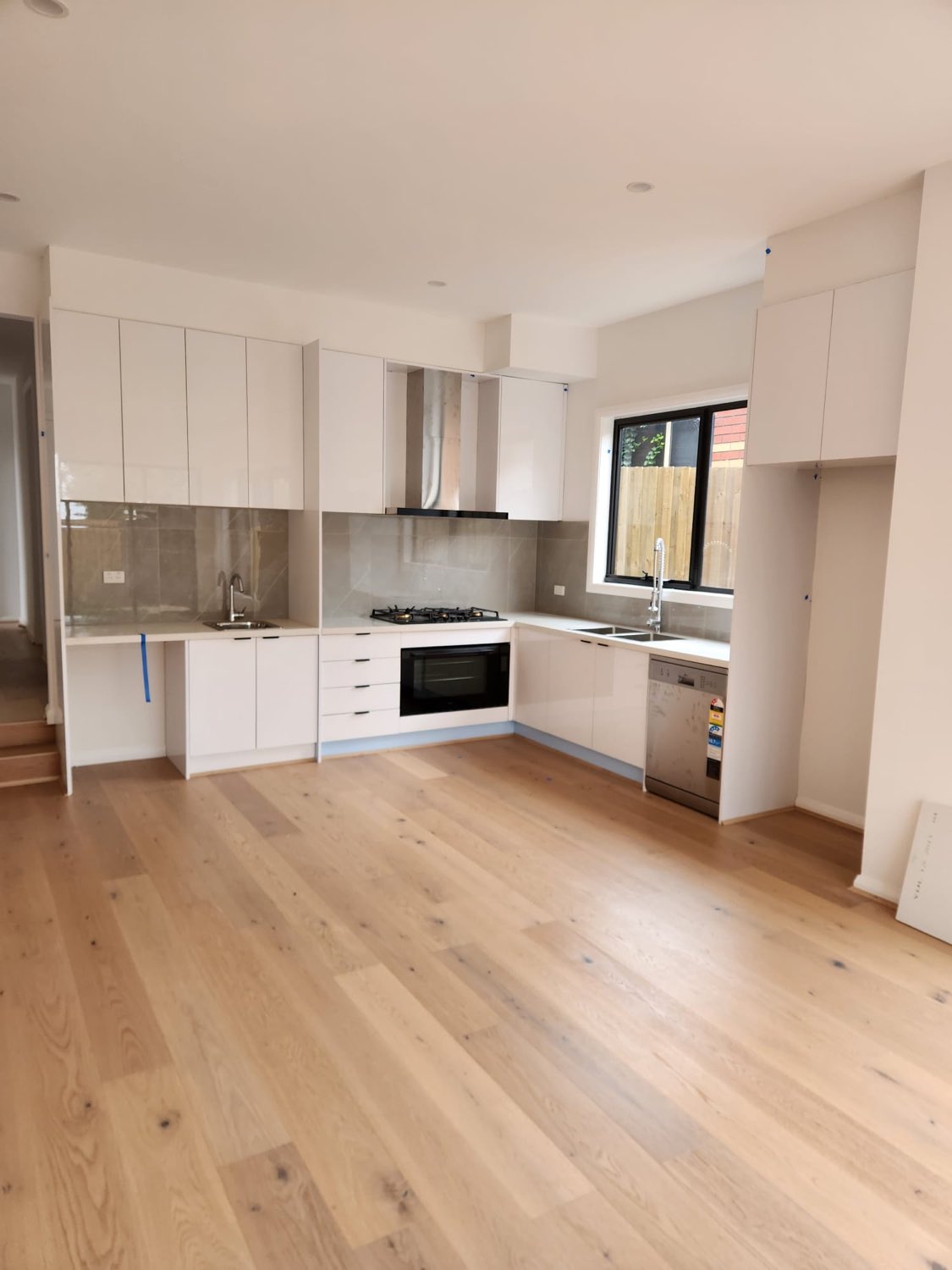 White gloss kitchen with timber flooring