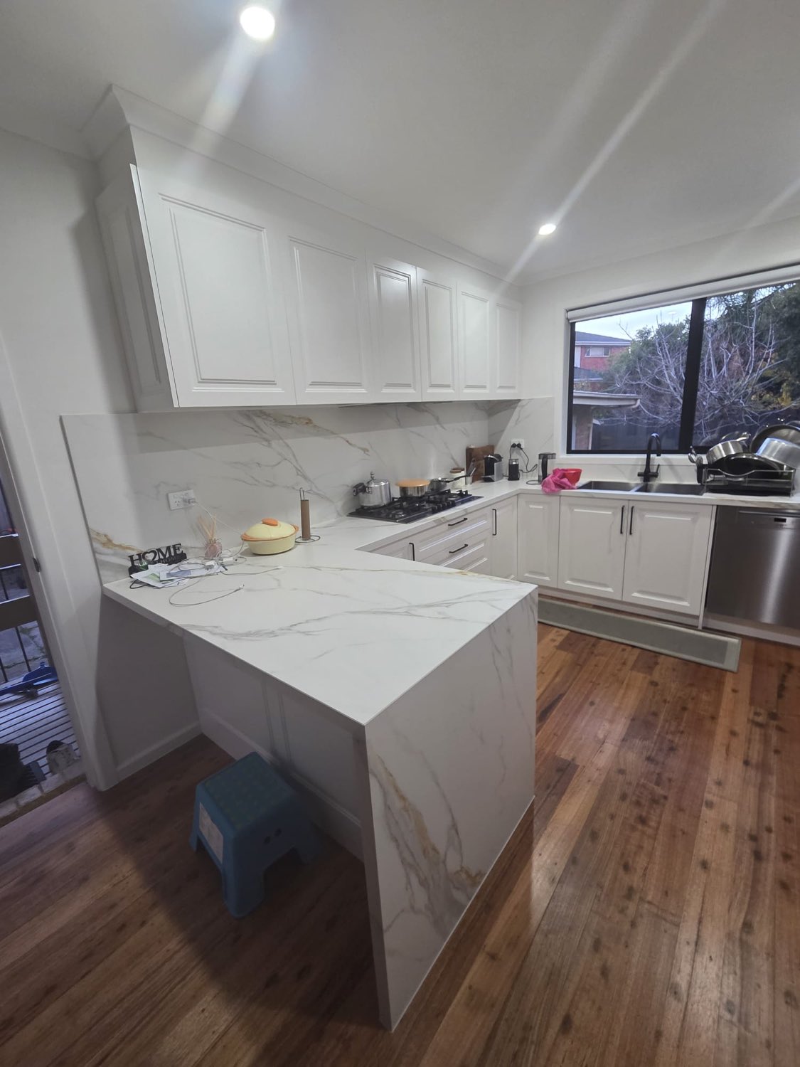 White shaker kitchen with marble waterfall edge