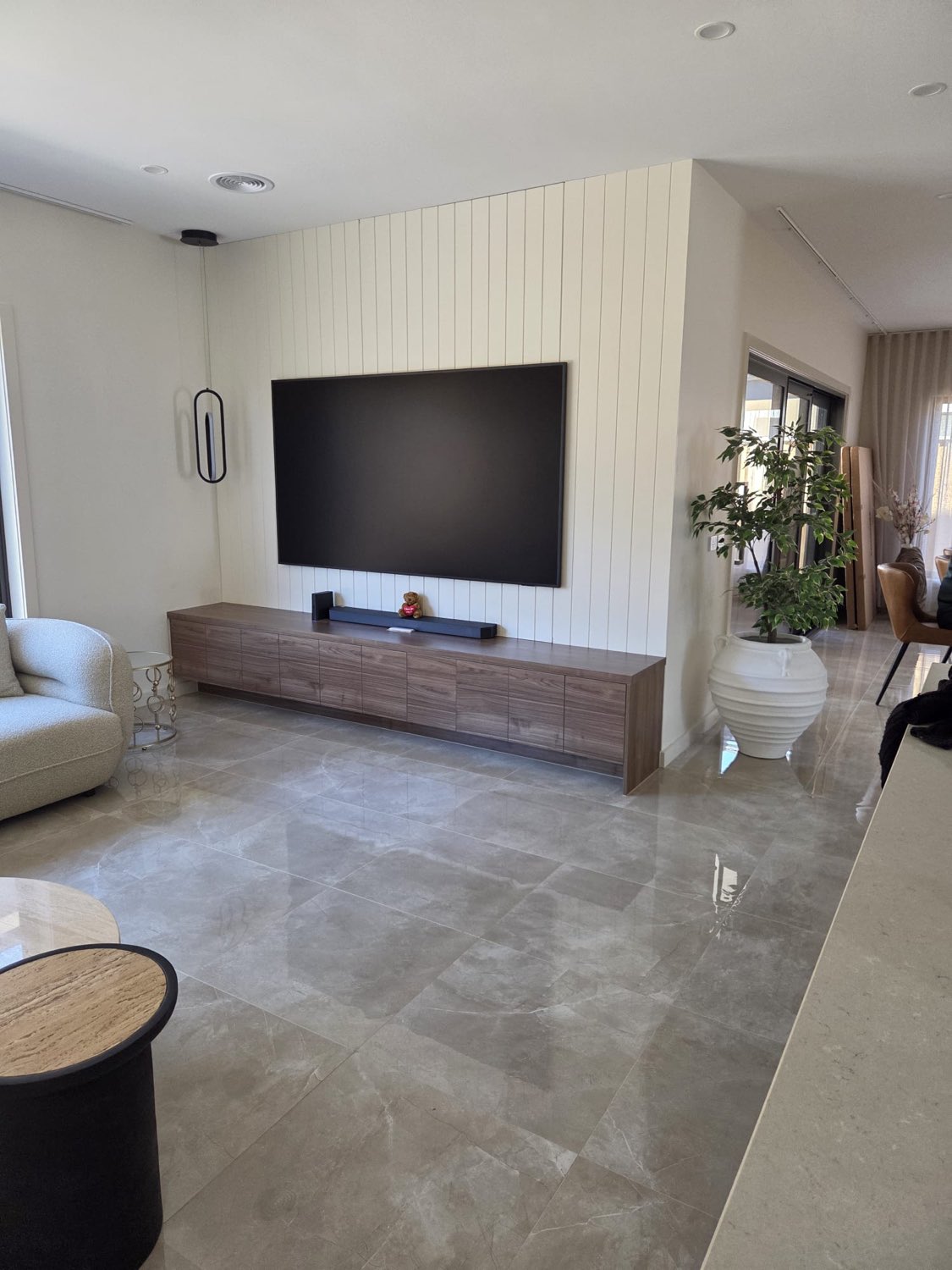 Walnut TV unit against panelled feature wall