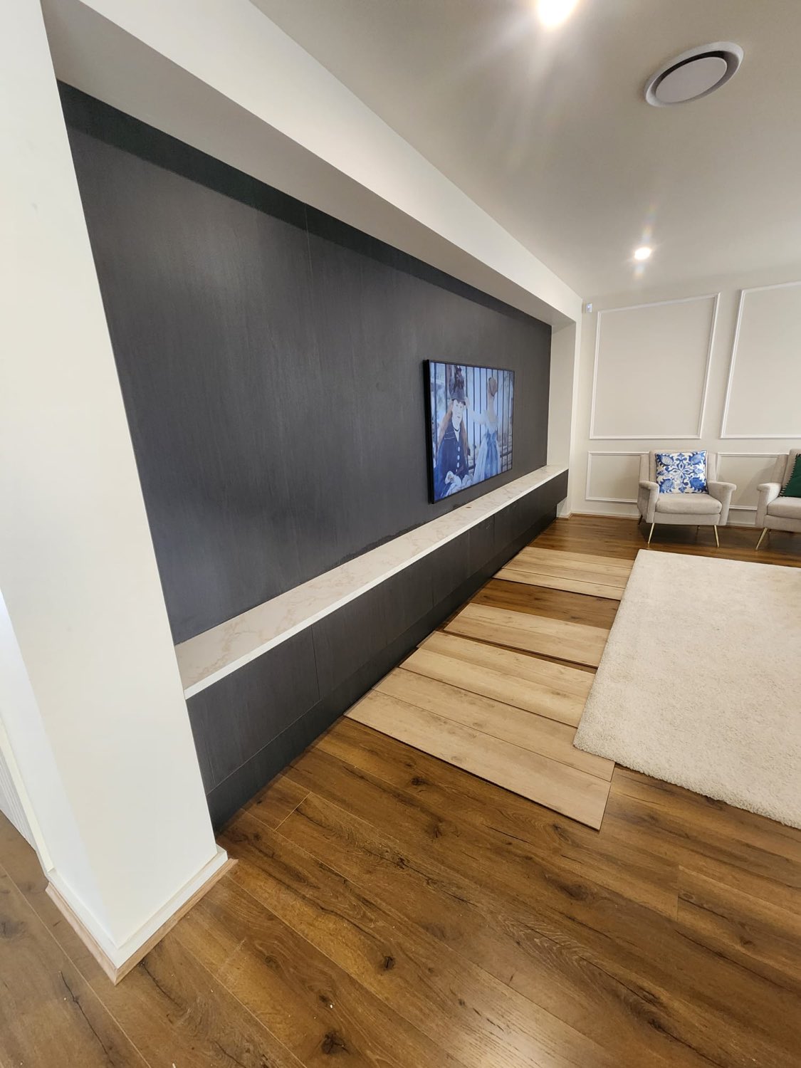 Dark feature TV wall with marble inlay shelf