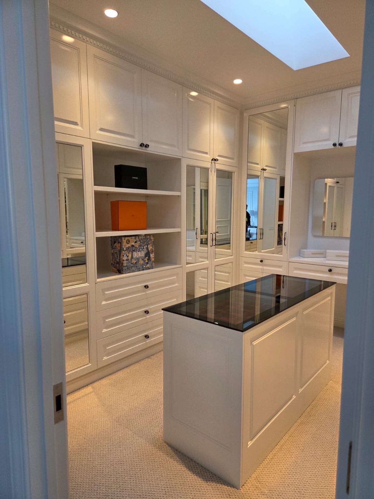 Walk-in dressing room with mirrored cabinetry, a recent Hashpry Services project