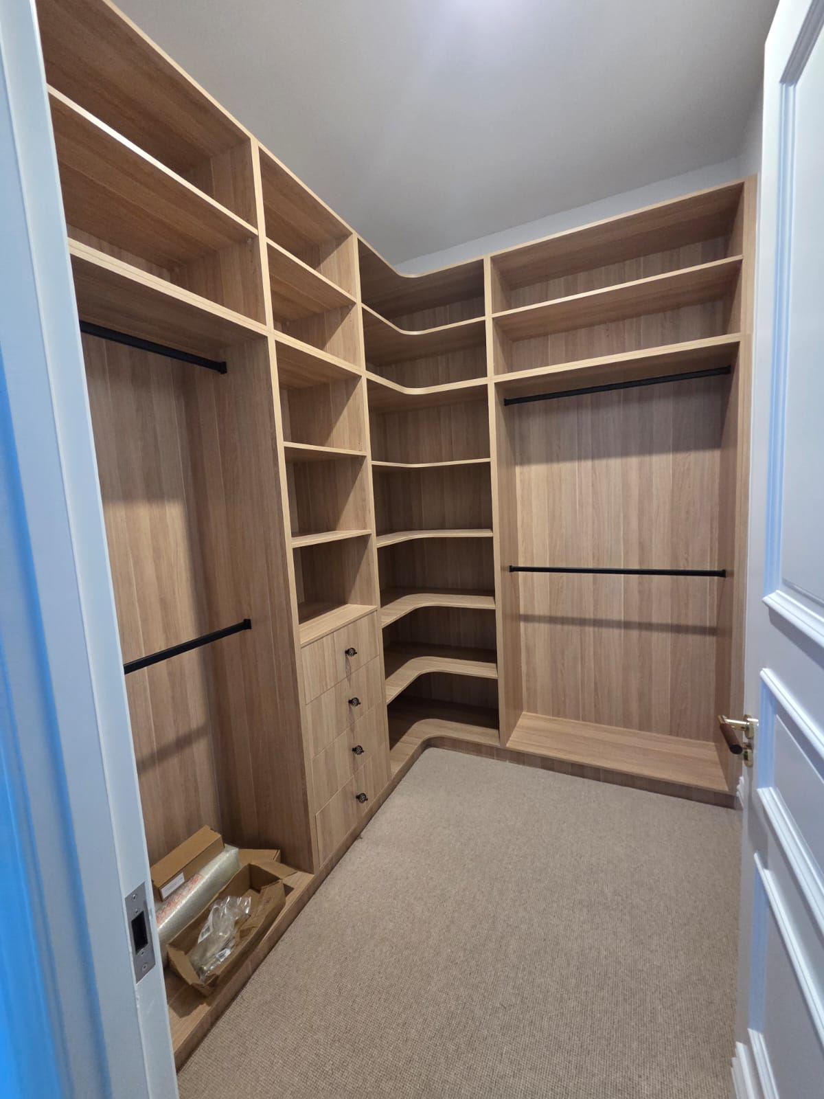 Oak walk-in wardrobe with wraparound corner shelving and drawer bank