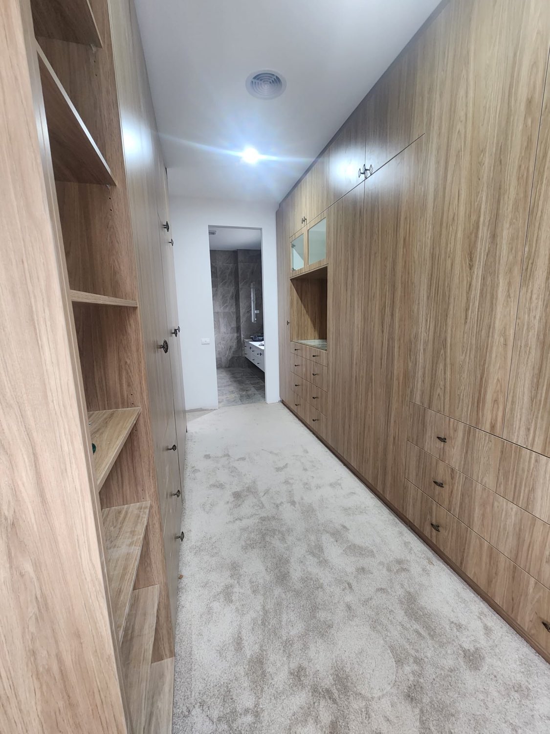 Timber walk-in wardrobe with full-height cabinetry
