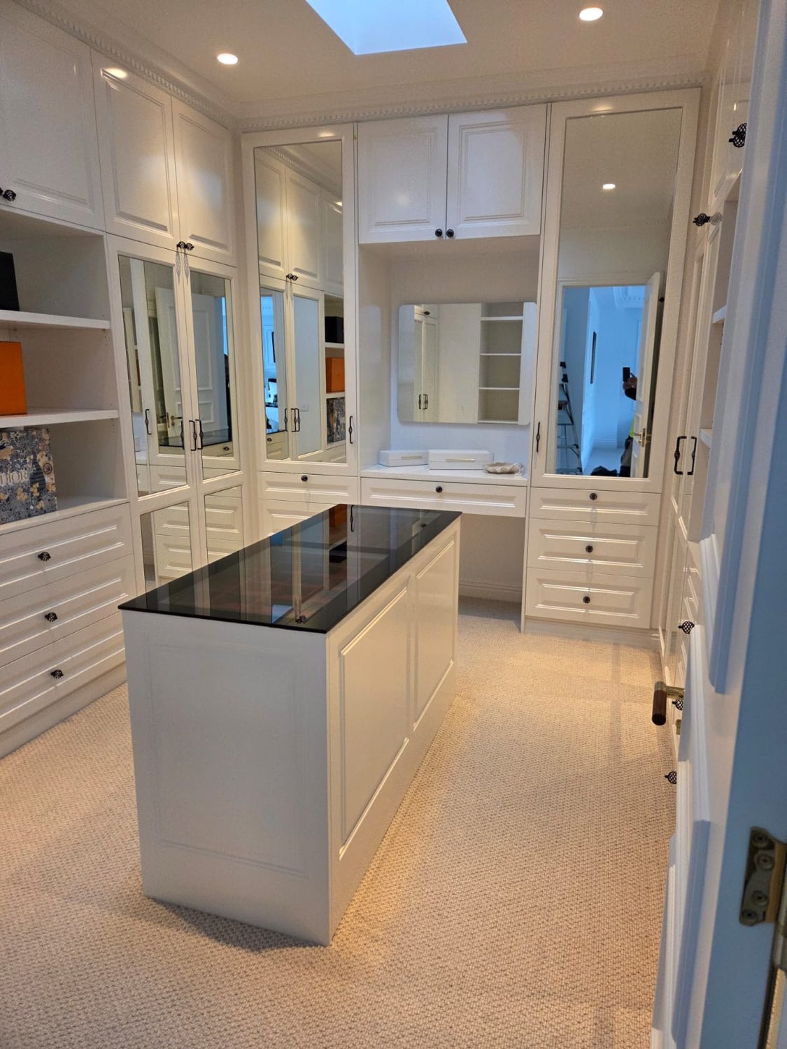 White walk-in dressing room with stone-top island