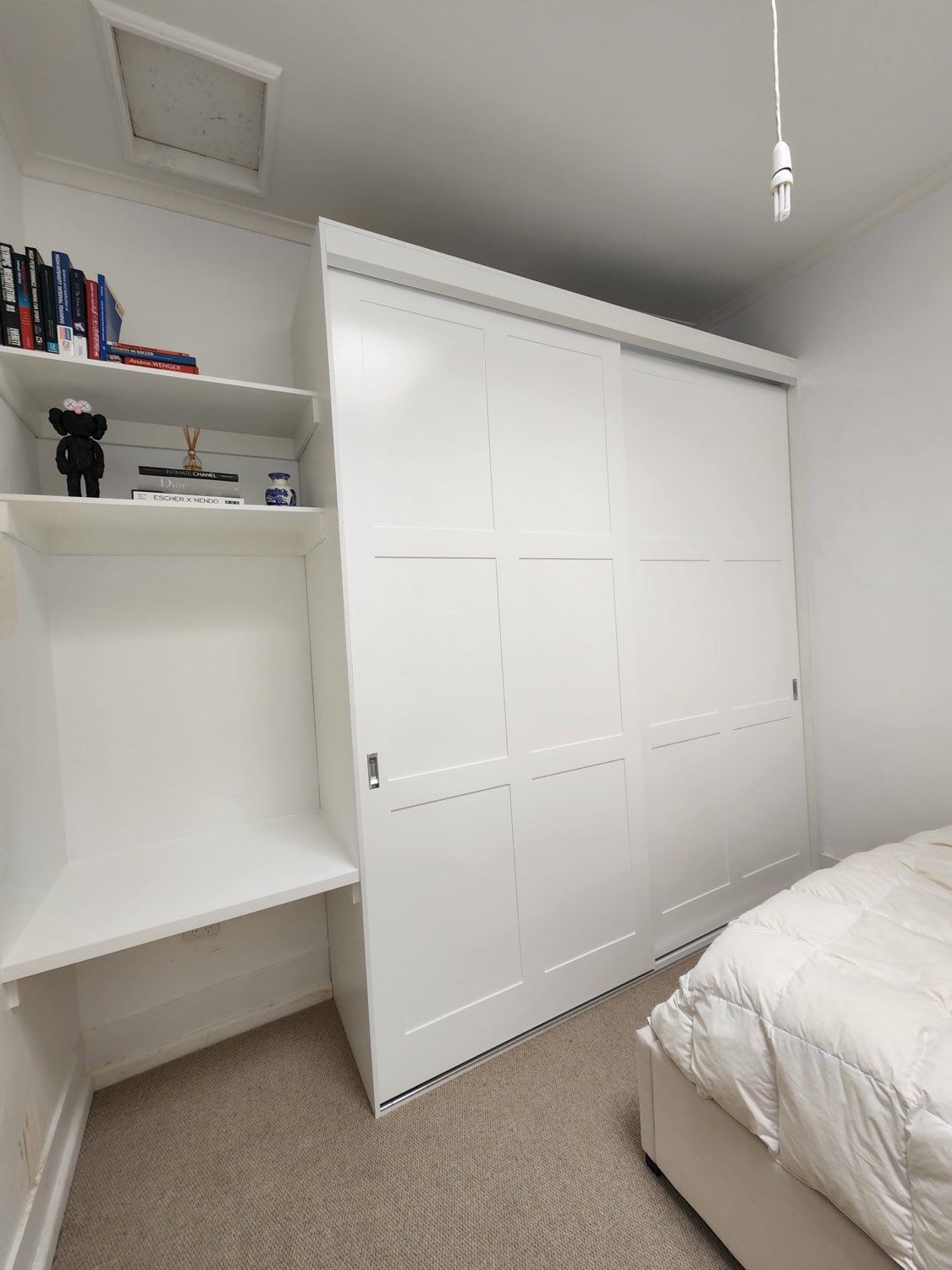 White sliding wardrobe with adjacent shelving